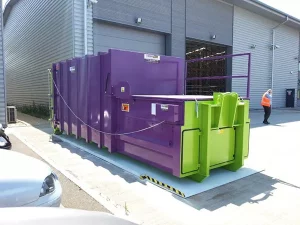 The purple Model L Roro compactor outside a warehouse.