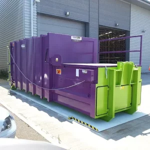 The purple Model L Roro compactor outside a warehouse.