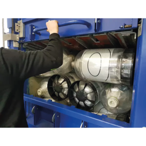 A picture of plastic kegs being placed into a plastic baler for processing