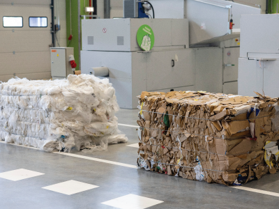 A cardboard bale and a plastic bale on the floor.